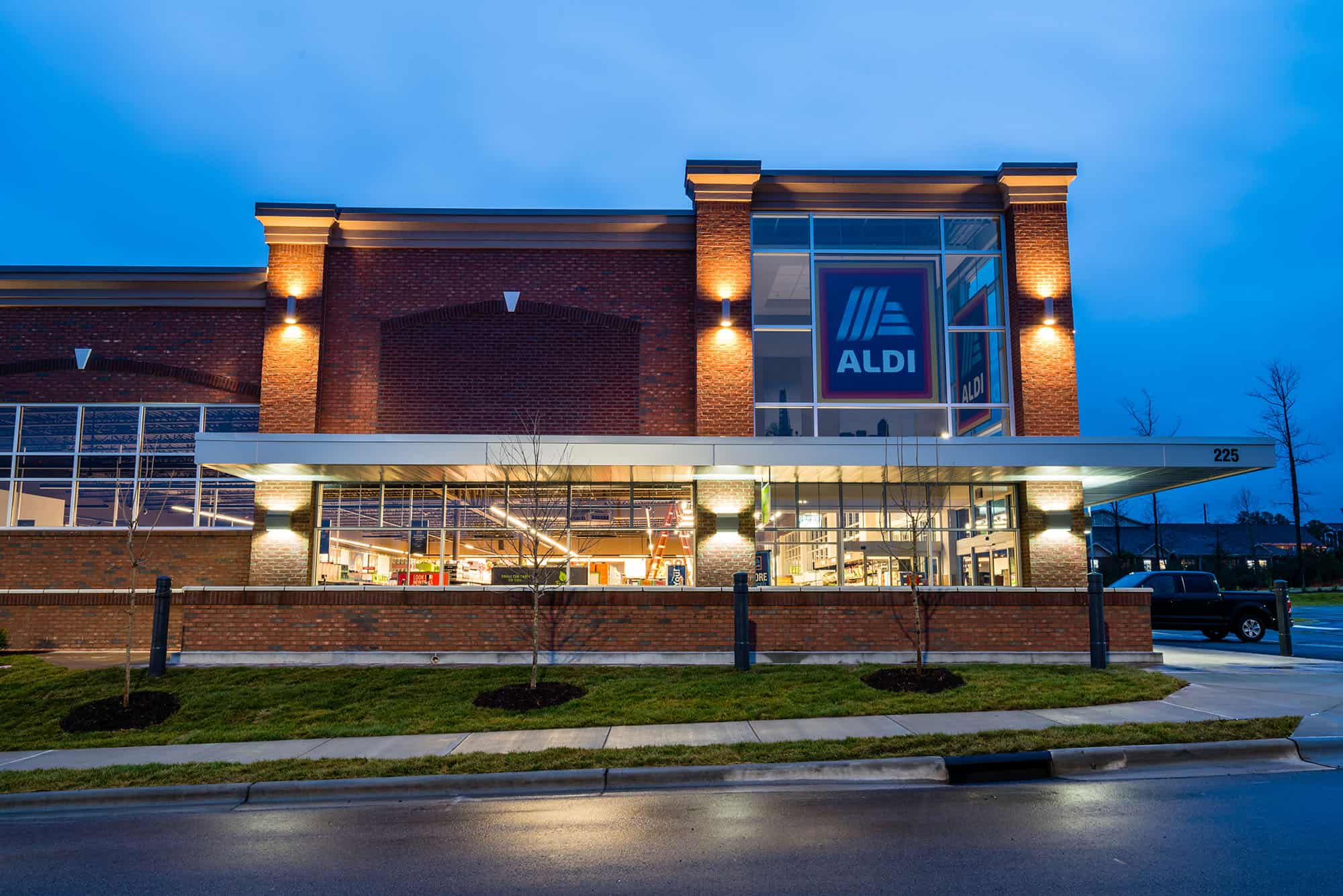 Night time, lit, side view from the street of our Aldi building project in Cary, NC